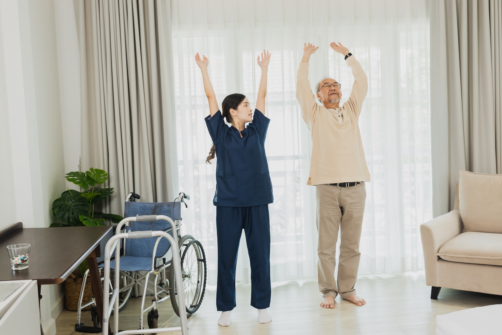 Asian nurse woman assisting old man warming up exercises for the upper body