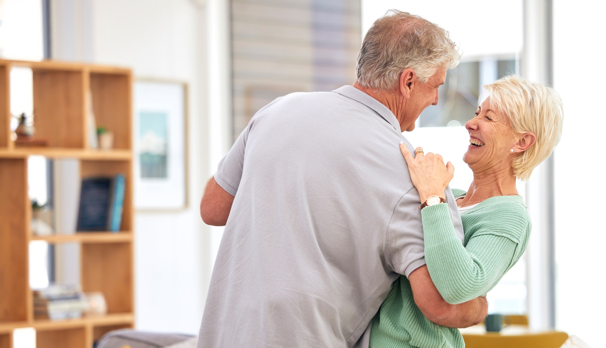 Funny, dancing or happy old couple laughing with love, care or smile in marriage at home together.
